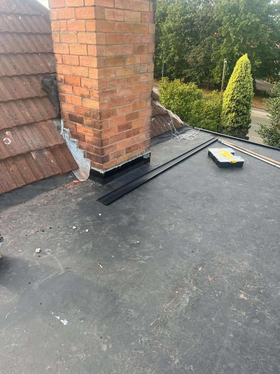 This is a photo of a flat roof which has just been repaired, there is also a chimney stack and some leadwork has also been dressed. Works carried out by Whiteley Roofing Repairs